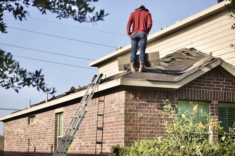 Professional roofer working on a residential roof in Kennedy House